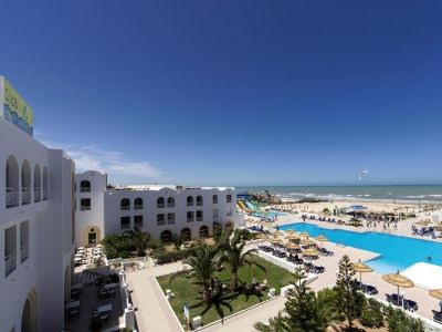 Eine große Hotelanlage mit Pool und Meer im Hintergrund